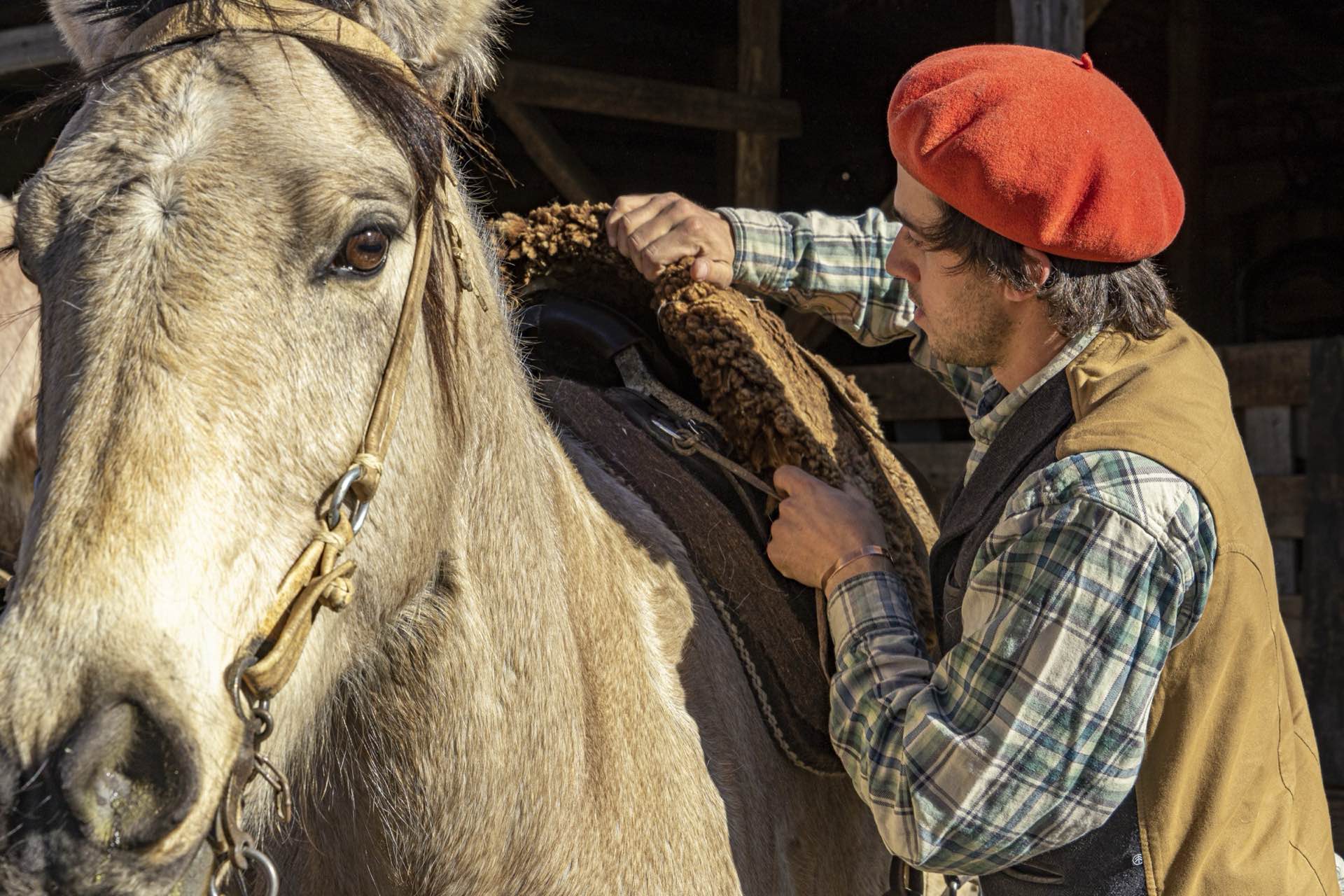 A gaucho saddling a horse at Arroyo Pescado