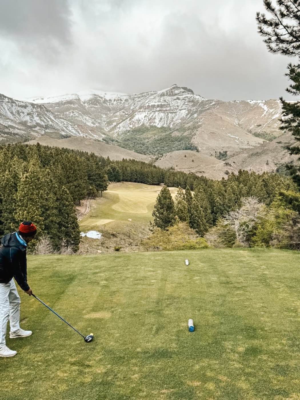 Golf beneath snow-capped mountains