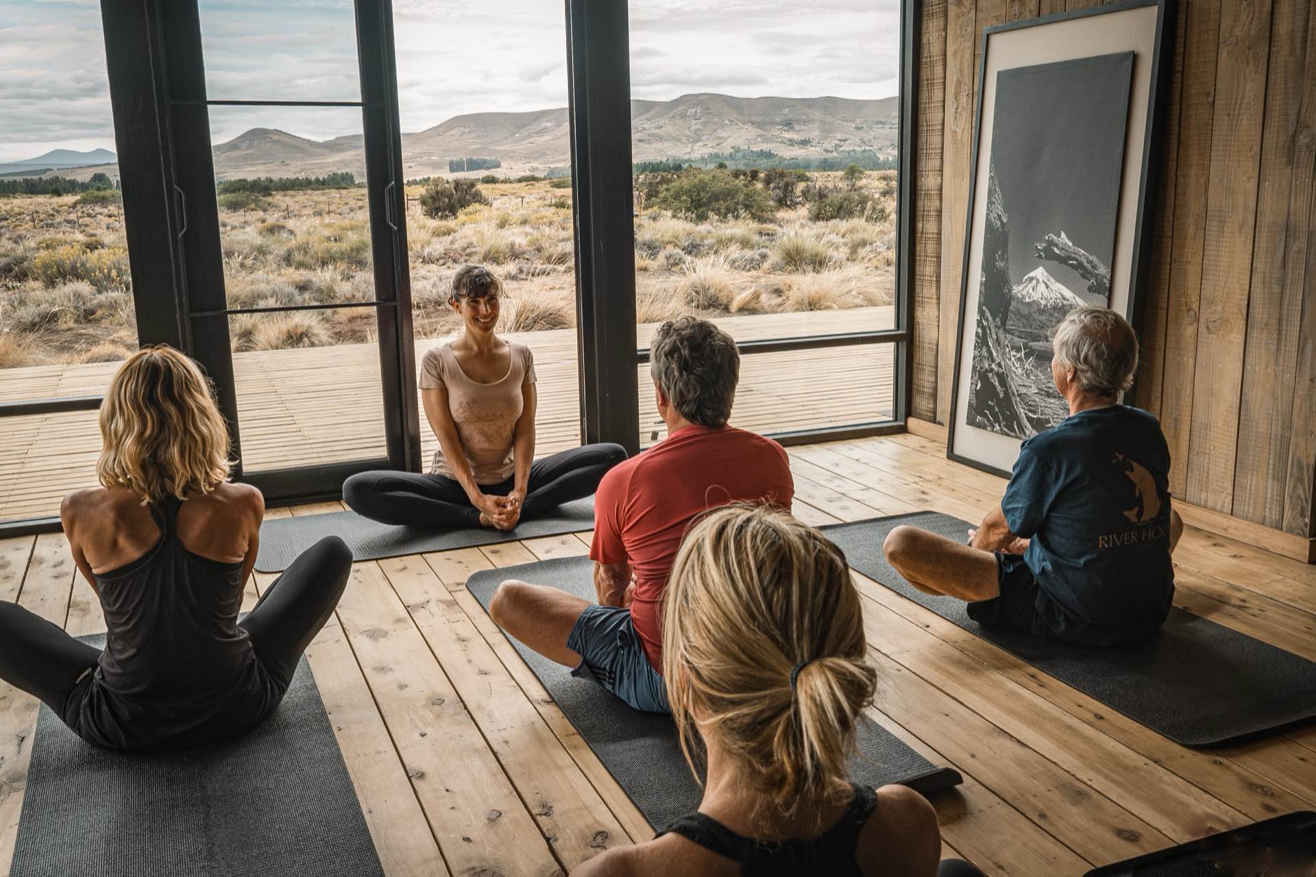 A yoga class in front of large windows
