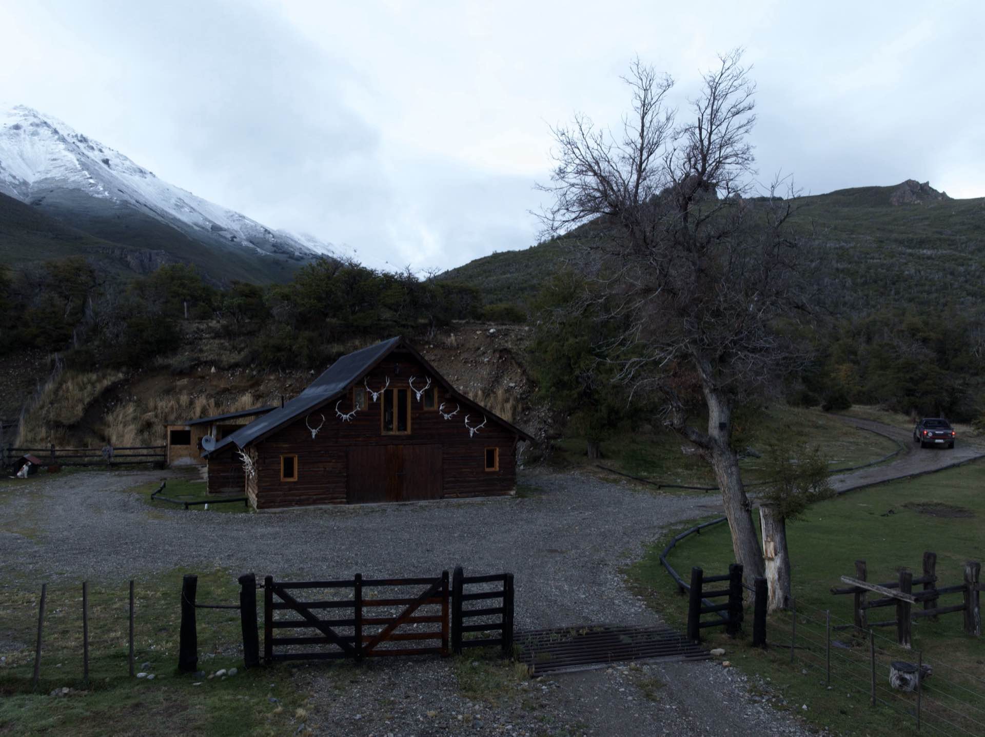 A wooden building at the foot of the mountains